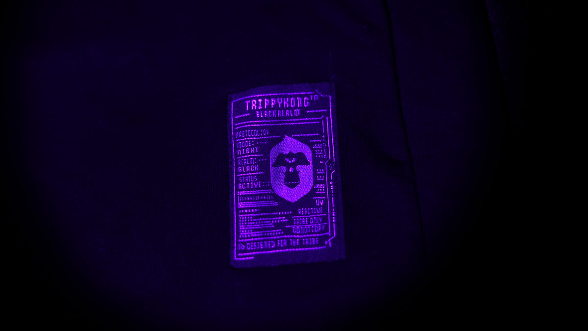 TrippyKong Black Realm Protocol-01 label illuminated in purple UV light.